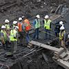 Workers and members of the media inspect the hull of a late 18th or early 19th century ship found at the World Trade Center site